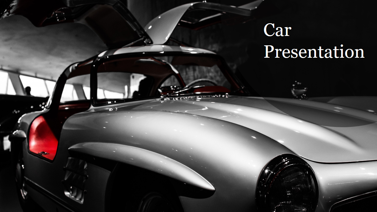 Close up view of a classic silver car with gullwing doors open, highlighted in a black and white photo with red accents.