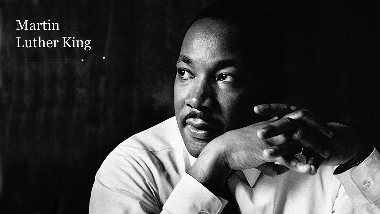 Black and white portrait of Martin Luther King Jr. with a contemplative expression, hands clasped.