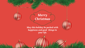 Christmas card slide with a red background, green pine branches, hanging red ornaments, and the message in the center.